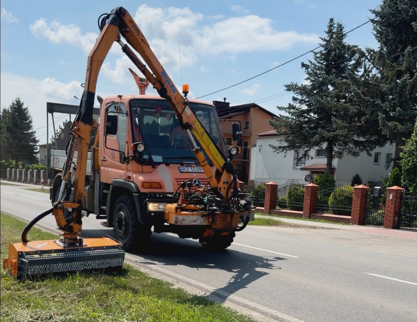 Lekka głowica kosząca ROLMEX GHL130 na wysięgniku Mercedes-Benz Unimog podczas koszenia pasa drogowego