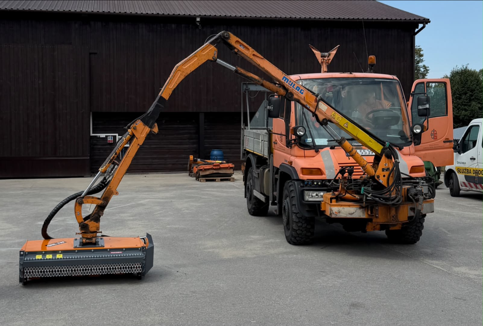 Lekka głowica kosząca ROLMEX GHL130 na wysięgniku Mercedes-Benz Unimog podczas koszenia pasa drogowego