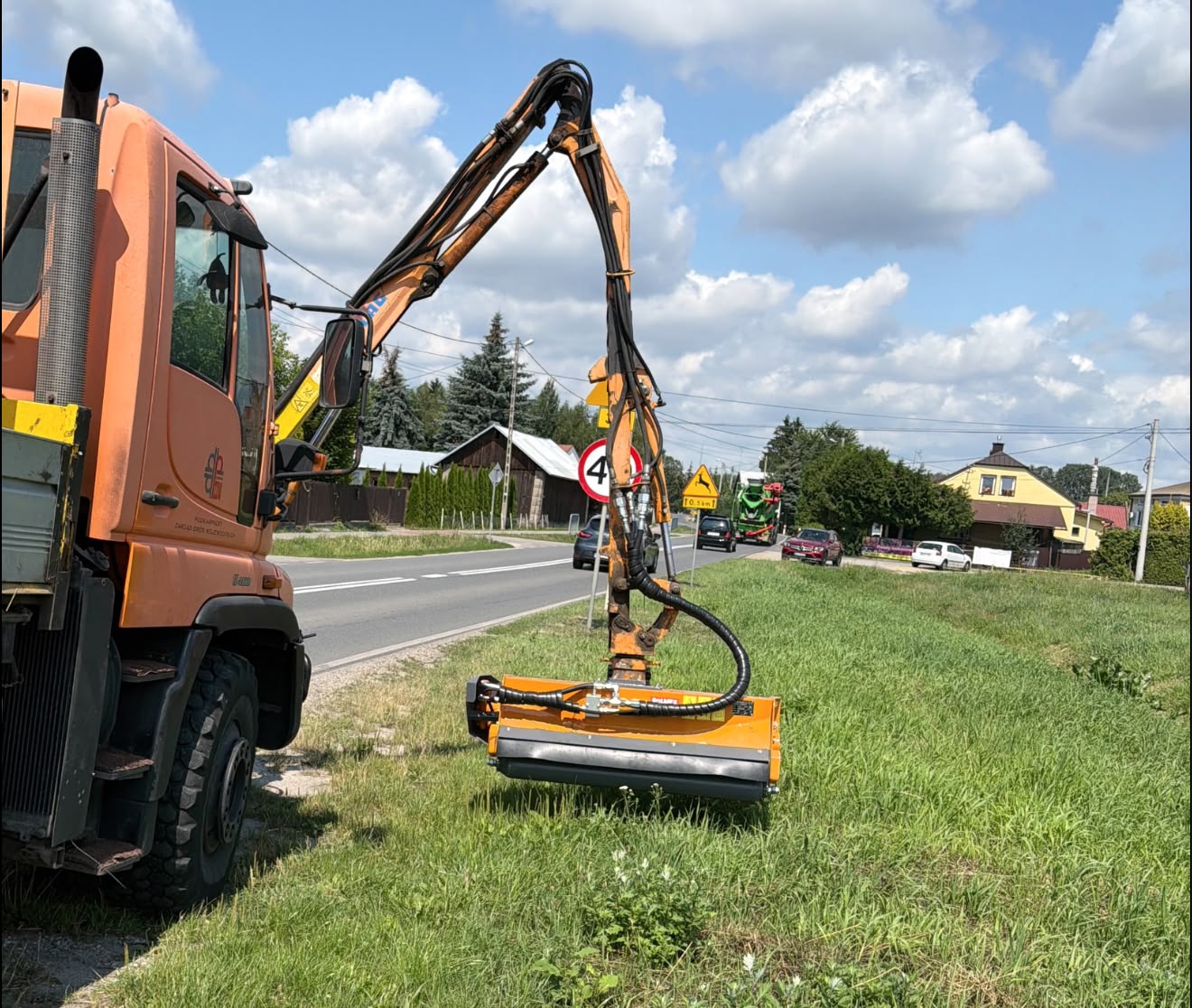 Lekka głowica kosząca ROLMEX GHL130 na wysięgniku Mercedes-Benz Unimog podczas koszenia pasa drogowego